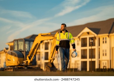 Builder on excavator. Builder worker with excavator. Builder in helmet. Worker in hardhat. Portrait mechanical worker in construction helmet. Engineer builder foreman or repairman. - Powered by Shutterstock