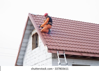 builder performs installation gable roof tiles of metal - Shutterstock ID 337803611