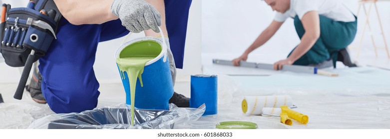 Builder Pouring Green Wall Paint Into Paint Tray