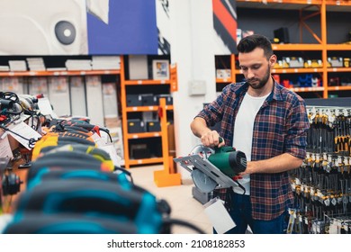 A Builder In A Power Tool Shop Picks Up A New Circular Saw.