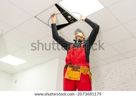 Builder replacing ceiling panel, working, ceiling armstrong