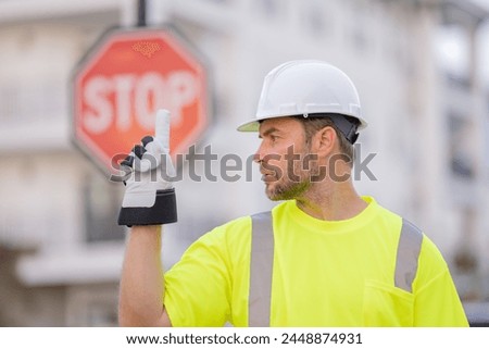 Builder with stop gesture, no hand, dangerous on building concept. Man in helmet showing stop road sign. Builder showing stop.