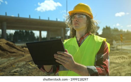 Builder With Tablet Pc At Road Junction Construction Site.