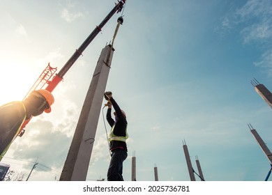 Builder team working installation prefabricated pillar concrete with crane lifting support in project house construction site.