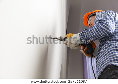 Builder or worker drilling with a machine or drill