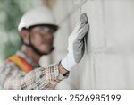 builder worker look at construction plastering wall for high precision detail and quality for good home build. builder professional engineer architect foreman hipster worker work in construction site