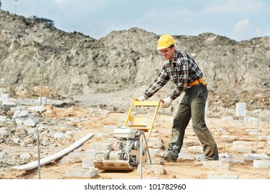 Builder Worker At Outdoor Sand Ground Compaction With Vibration Plate Compactor Machine Before Concrete Filling