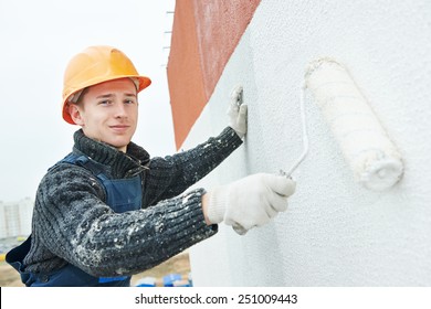 Builder Worker Painting Facade Of High-rise Building With Roller