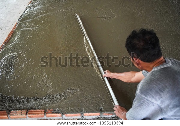 Builder worker\
plastering concrete cement\
floor