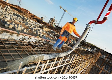 builder worker standing near trailer-mounted boom concrete pump on metal rods reinforcement of concrete casting formwork