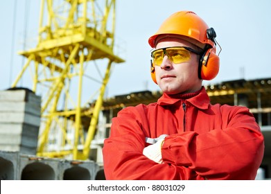 builder worker in uniform and safety protective equipment at construction site - Powered by Shutterstock