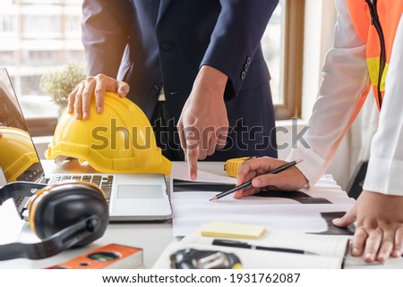 Builder young engineer man and architect woman are discussing construction from a plan to follow the project to build an industrial plant at site. Worker concept.
