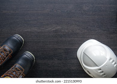 Builder's Helmet And Boots On A Wooden Background, Top View.