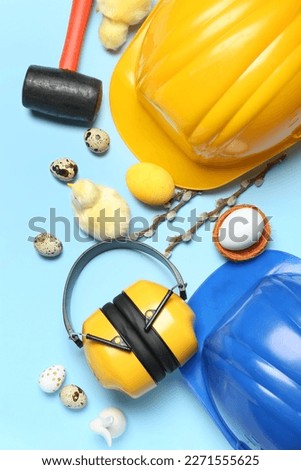 Builder's tools with chickens, Easter eggs and willow branches on blue background