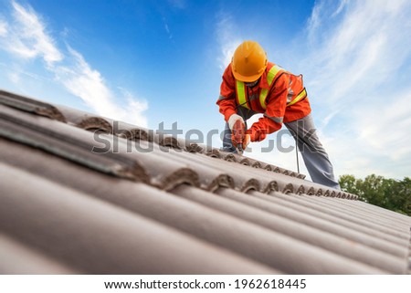 Builders in work clothes install new roofing tools, roofing tools, electric drill and use them on new wooden roofs with metal sheets Сток-фото © 