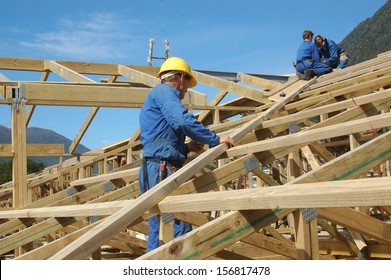 Builders Working On The Roof Of A Large House