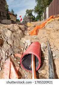 Building 5G net. Cables sticking out of the ribbed safety tube in the street, detail of an excavation. Internet and data provider company building the pshychical connection