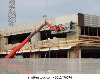 Building Activity. Cherry Picker At Work On A Facade Of A New Construction Building