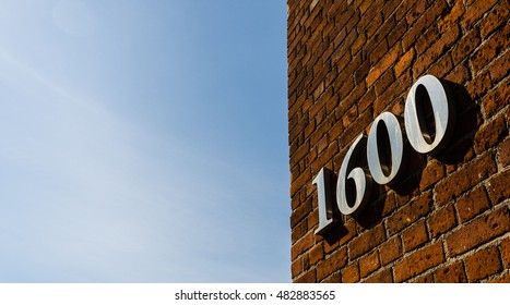 Building With Address Sign Saying 1600 Against Blue Sky On A Sunny Day