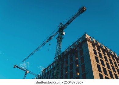 building around crane construction equipment. Construction of apartment building from concrete, monolithic slabs. Industrial construction of houses,developer company,construction crane.