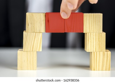 Building A Business Concept. Closeup Of Businessman Making A Bridge With Wooden Toy Cubes. 