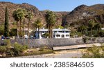 A building in Clifton, Arizona, surrounded by palm trees with mountains in the background, in Greenlee County, USA, not far from New Mexico, in autumn and fall of 2023.
