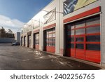 Building with a commercial vehicle repair shop with six garage doors. Modern garage with automatic gates for trucks and large cars. Exterior view..