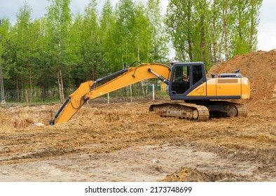 Building concept. An excavator is digging a pit for a house. - Shutterstock ID 2173748699