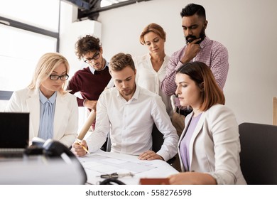 building, construction, architecture, real estate and people concept - business team with blueprint meeting and discussing house project at office - Shutterstock ID 558276598