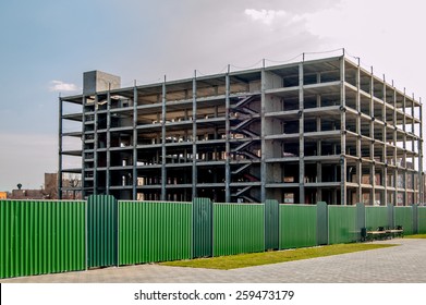 Building Construction Copyspace On The Sky Toned Colorized Image. Construction Site. Modern Building Under Construction And Green Metal Fence