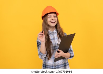 Building And Construction. Happy Child Worker Wear Hardhat Hold Clipboard. Childhood Development. Happy Labour Day. Future Career. Teen Girl In Helmet Making Notes. Builder Kid Write In Folder.