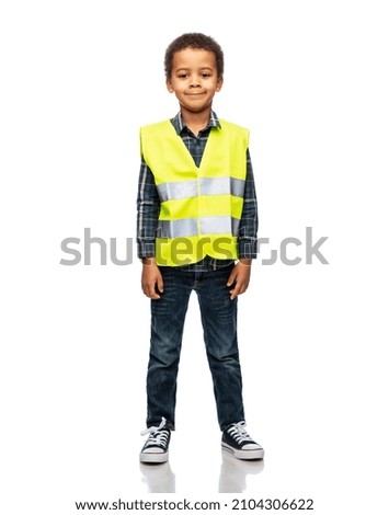 building, construction and profession concept - smiling little boy in yellow safety vest over white background