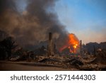 A building consumed by flames as powerful winds intensify devastating wildfires in Los Angeles, showcasing the ferocity of nature