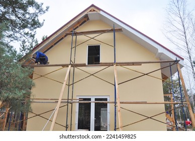 Building contractor installing fascia and soffit board on new painted house.  - Shutterstock ID 2241459825