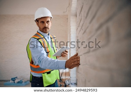 Building contractor using digital tablet during construction site inspection. Copy space.