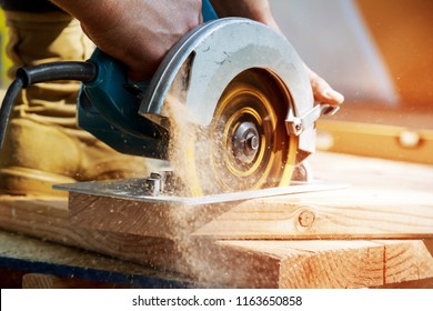 Building contractor worker using hand held worm drive circular saw to cut boards on a new home constructiion project - Shutterstock ID 1163650858