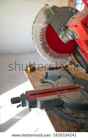 Building contractor worker using hand held circular saw to cut boards on a new home constructiion project sit