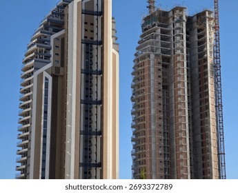 building contrasts sky, structures showcasing completed and underconstruction elements against blue