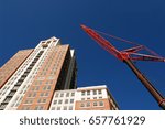 Building Crane / construction crane next to building pointing toward sky
