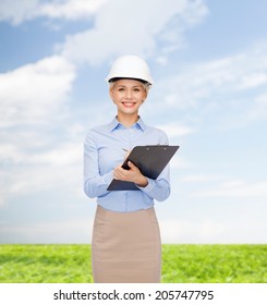building, developing, construction and architecture concept - smiling businesswoman in white helmet with clipboard