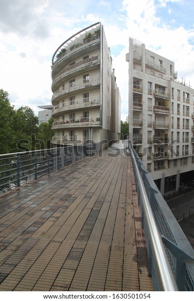 the building is divided in half by a bridge in empty\
streets Paris 