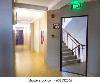 Building Emergency Exit with Exit Sign and Fire Extinguisher. stairwell fire escape in a modern building.