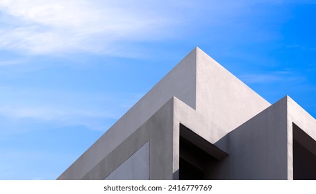 Building Exterior Architecture. Abstract Geometric Concrete Wall in Triangle Shape of Minimal Office Facade against Blue Sky Background, Low Angle and Perspective side view - Powered by Shutterstock