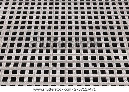 Building facade forming a grid pattern with repetitive window openings