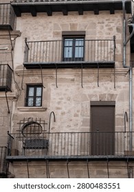 Building facade with multiple balconies, windows, and ironwork details