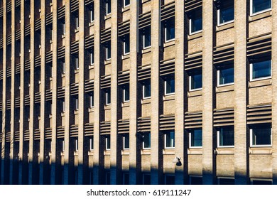 Building facade with repeating pattern of windows and brick columns