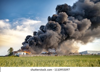 Building Fire Among Fields And Huge Black Smoke Cloud