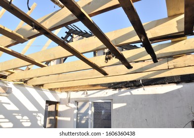 Building A House After A Fire. New Wooden Rafters. Charred Boards