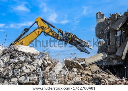 Building House Demolition site Excavator with hydraulic crasher machine and yellow container