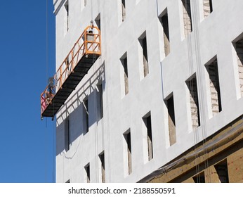 Building house. Finishing works. Facade lift. Construction site. Contrasting shadows. Perspective distortions.
				